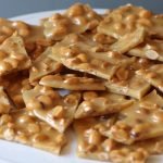 pile of classic peanut brittle on a white plate.