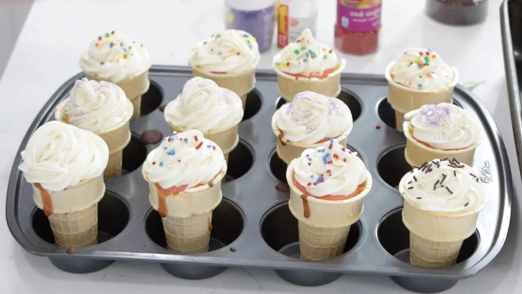 Decorated ice cream cone cupcakes in a muffin pan.