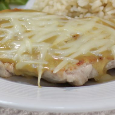grilled pork loin chop topped with honey mustard glaze and cheese