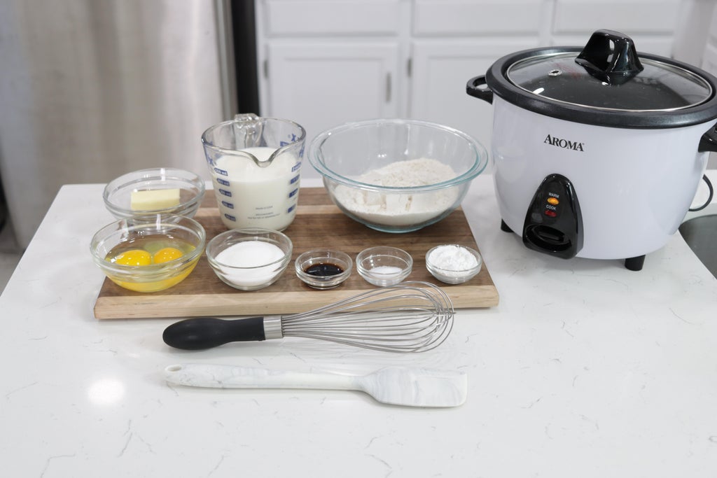 Rice cooker and pancake ingredients on a counter.