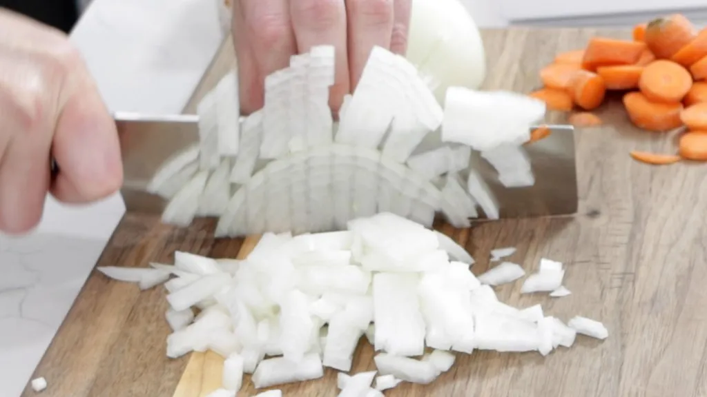 Knife slicing and chopping an onion.