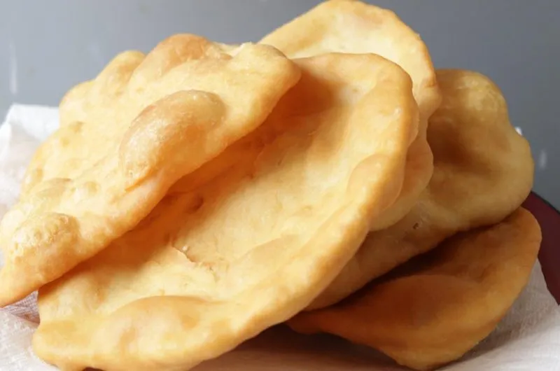 Indian fry bread stacked on a plate with paper towel