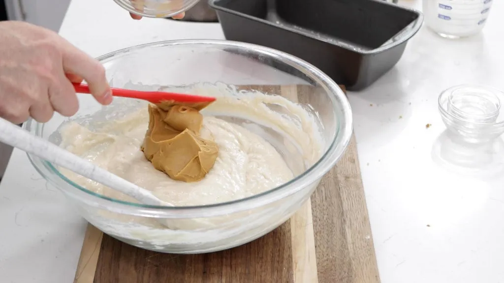 Peanut butter being added to the batter.