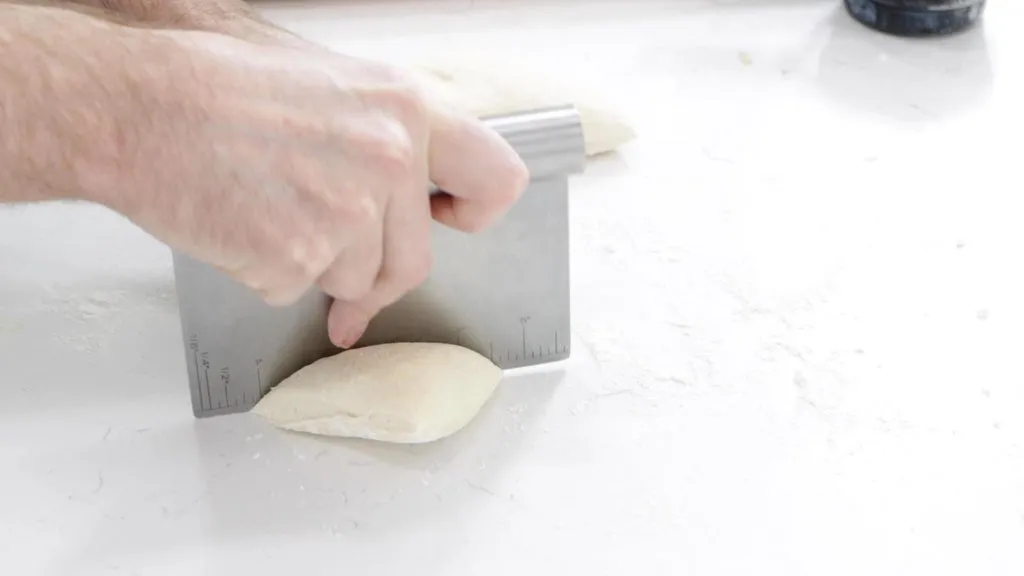 Hand with dough cutter cutting the fry bread dough.