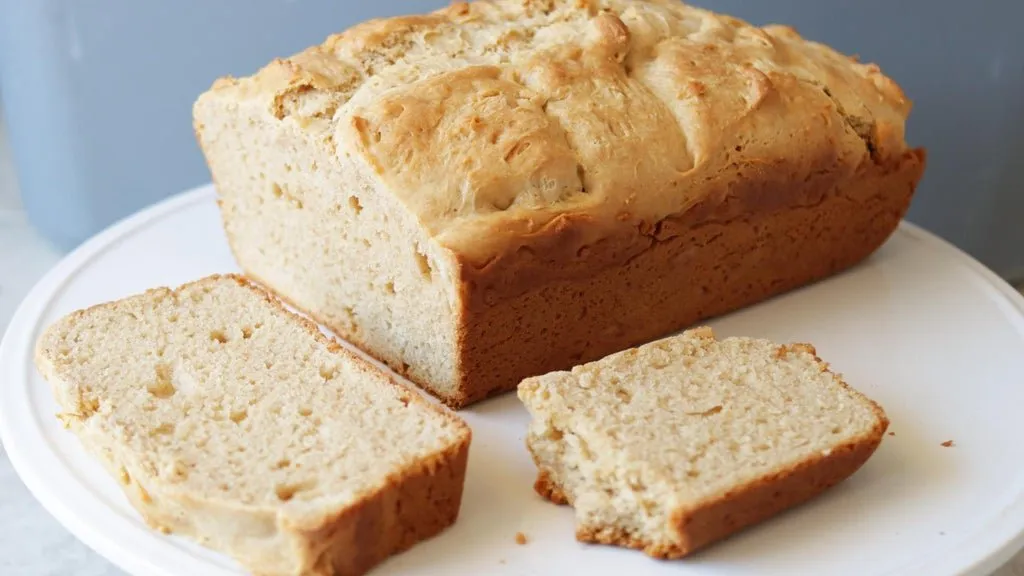 Loaf of homemade peanut butter bread on a white plate.