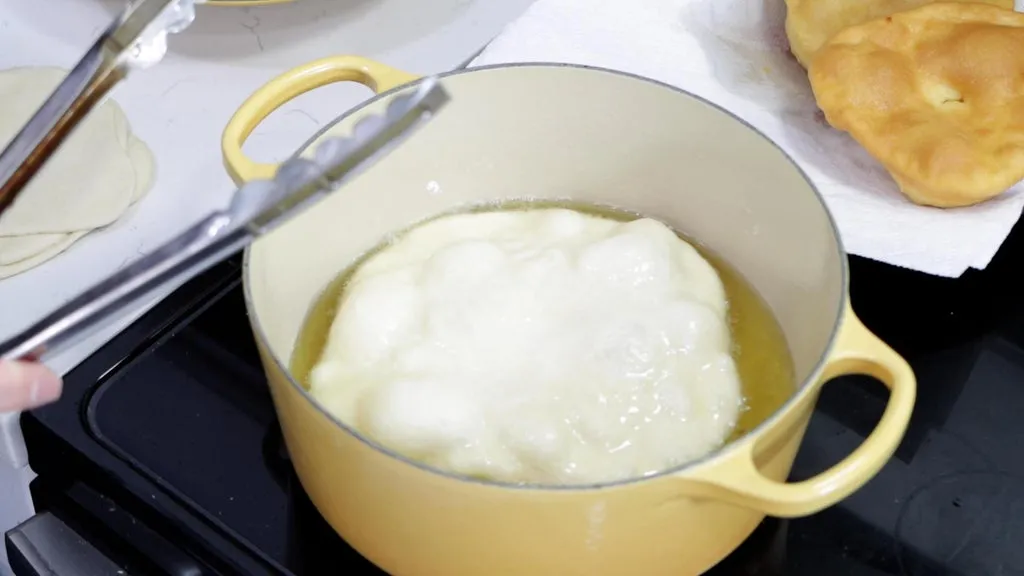 Bread dough in a pot of oil.