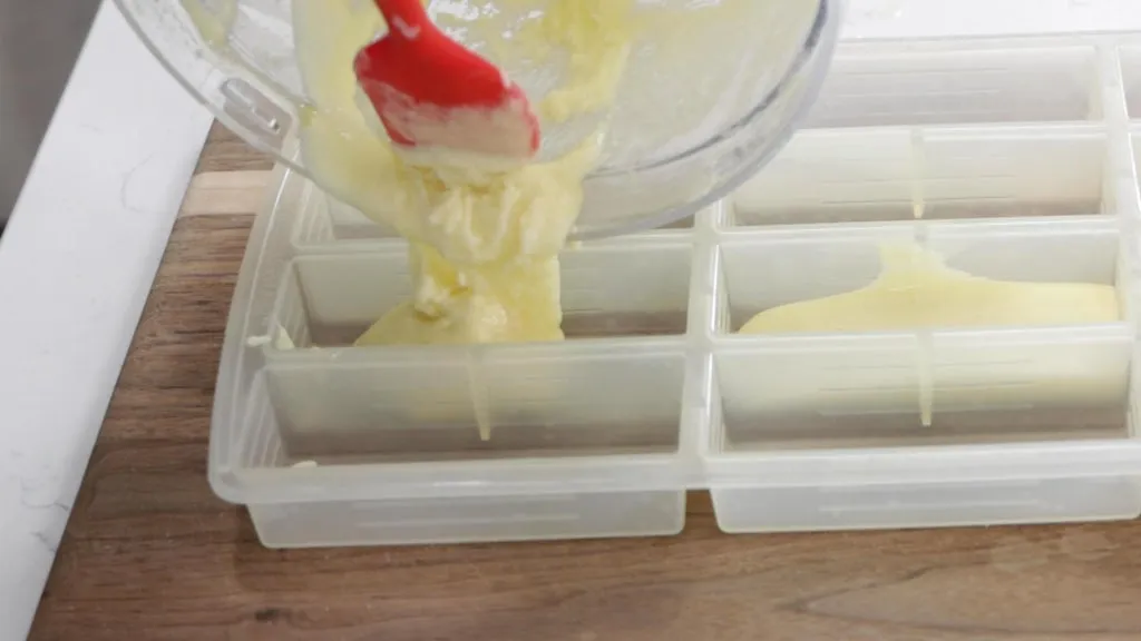 Pouring melted white chocolate into molds.