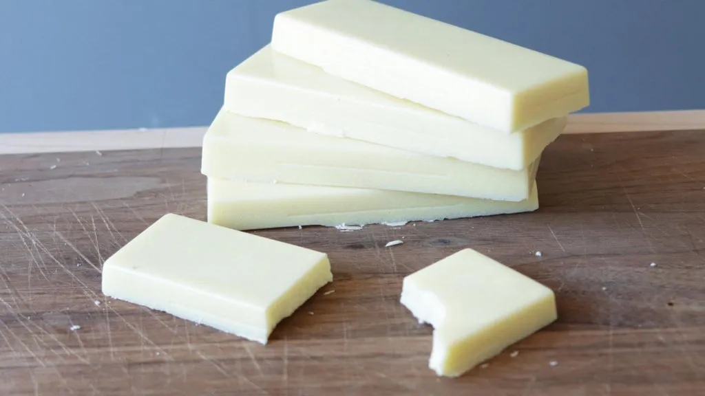 Stack of homemade white chocolate on a cutting board.
