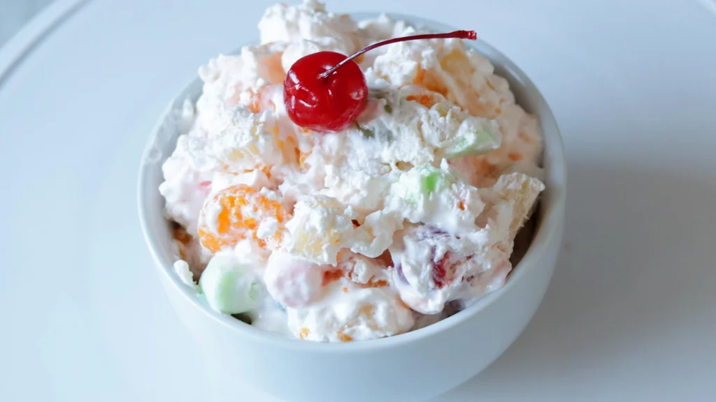 Bowl filled with ambrosia salad on a white plate.