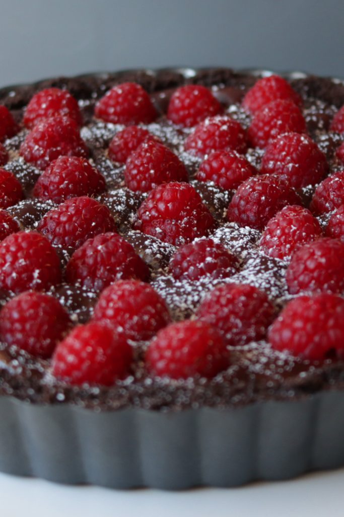Homemade chocolate raspberry tart showing a closeup of all the raspberries. Homemade chocolate raspberry tart showing a closeup of all the raspberries.