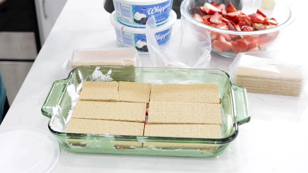 6 full length graham crackers on top of a layer of strawberries.