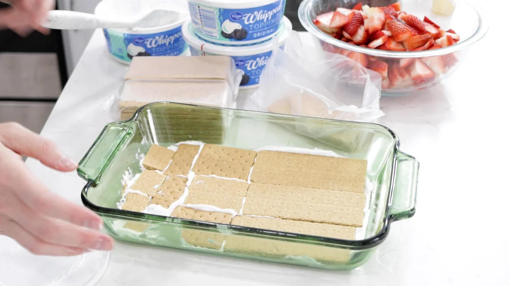 Layer of graham crackers over the whipped cream in a glass baking dish.