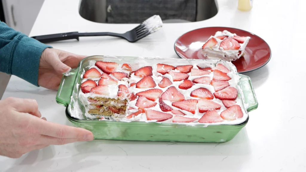 Hand holding a strawberry icebox cake