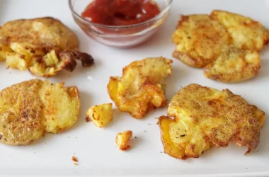air fryer smashed potatoes on a plate with a bowl of ketchup