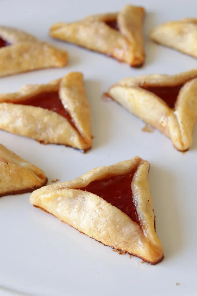 Several hamantaschen on a white plate.