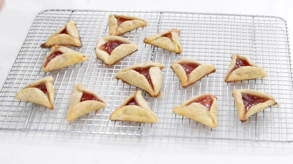 Several Hamantaschen on a wire rack.