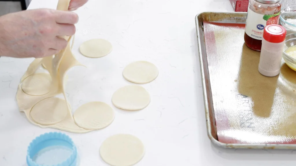 Hand holding pie crust scraps.