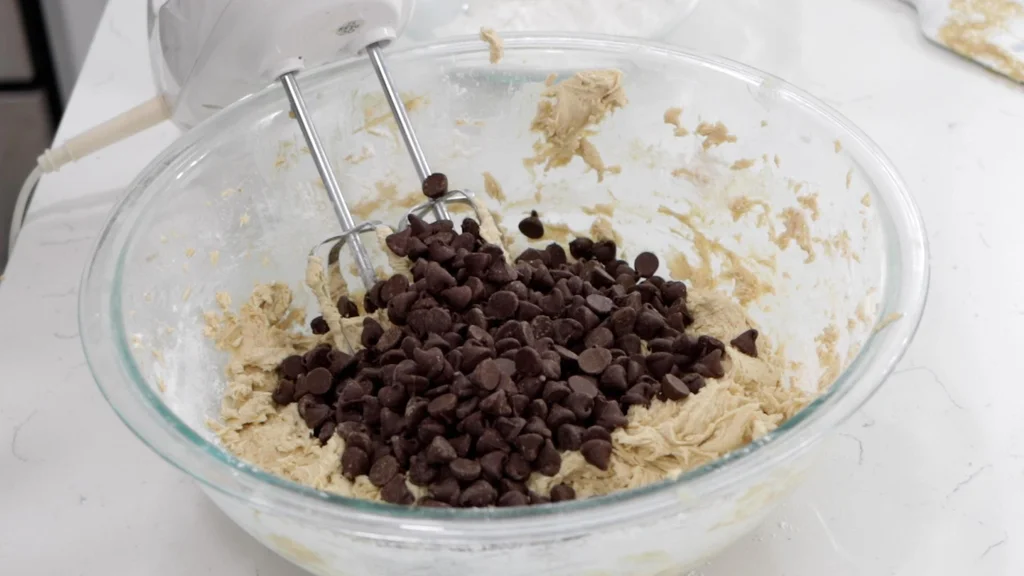 Chocolate chips added to the bowl of cookie dough.