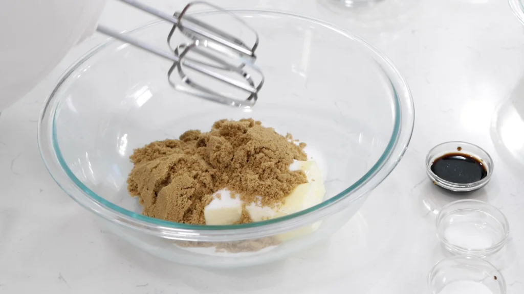 Brown and white sugar in a large bowl with butter and a mixer