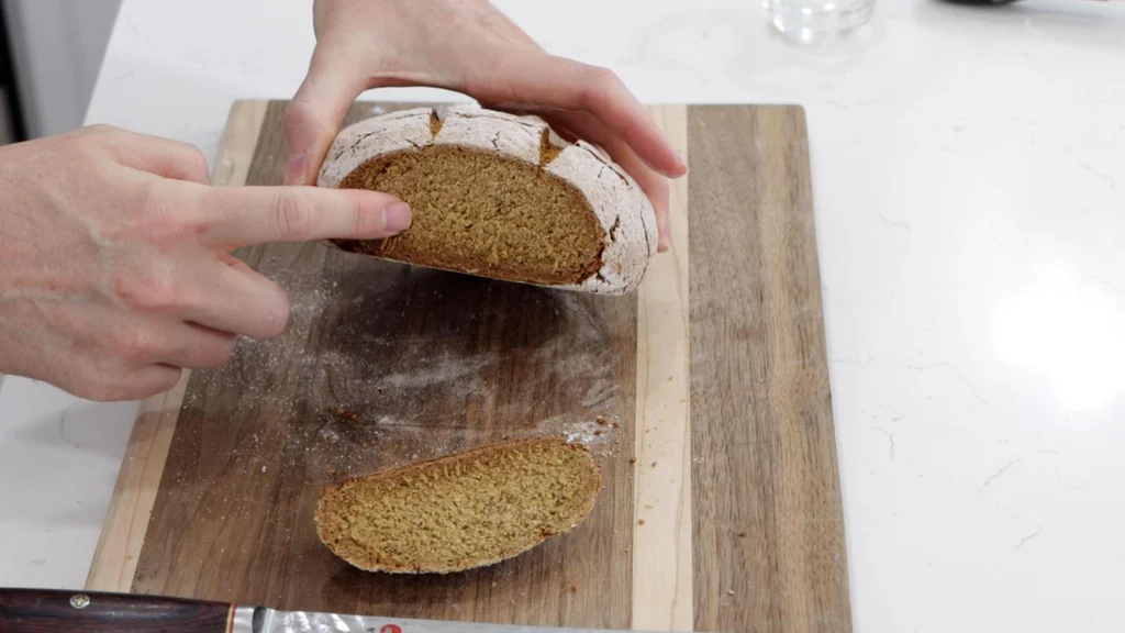 Sliced rye bread on a wooden cutting board.