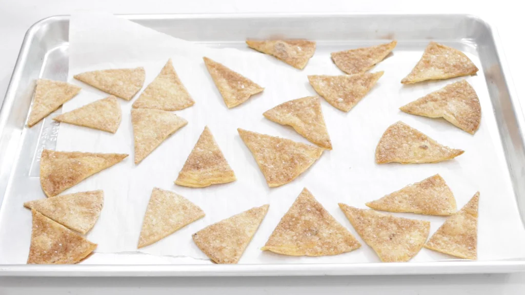 Finished homemade cinnamon sugar tortilla chips on a sheet pan.