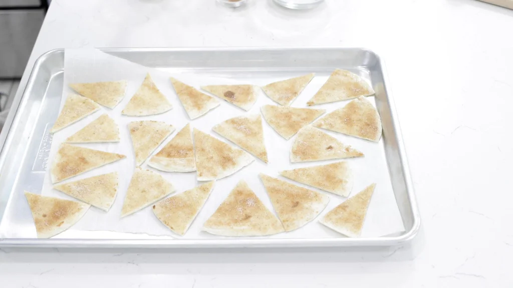 Sheet pan filled with unbaked cinnamon sugar tortilla chips