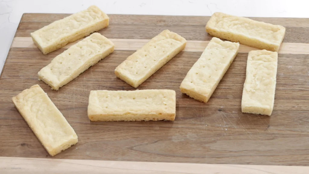 Fresh homemade Scottish shortbread cookies on a wooden cutting board.