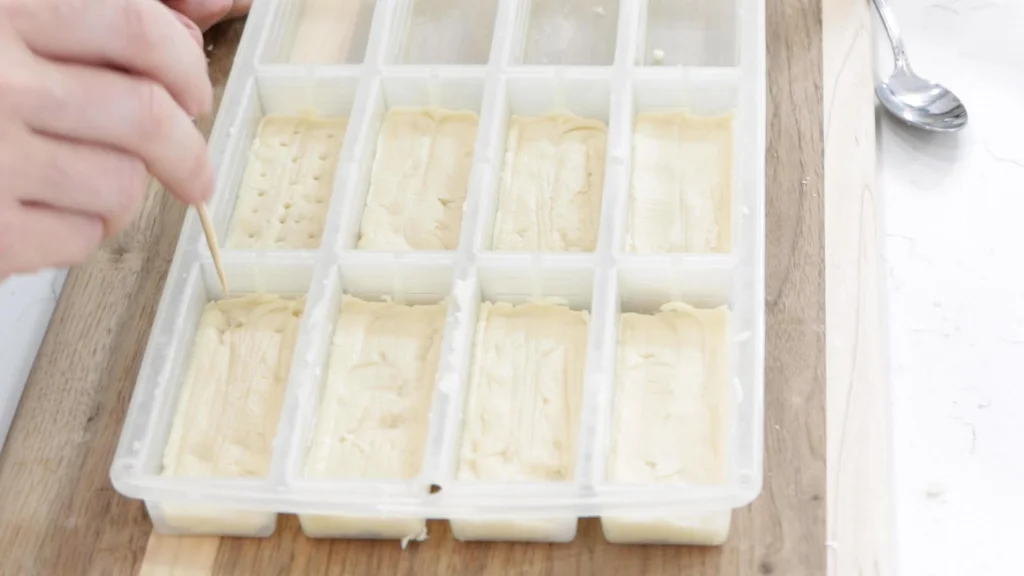 Hand poking holes in the shortbread with a wooden skewer