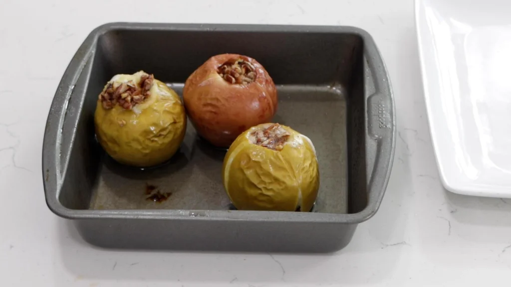 Baking pan full of stuffed baked apples.
