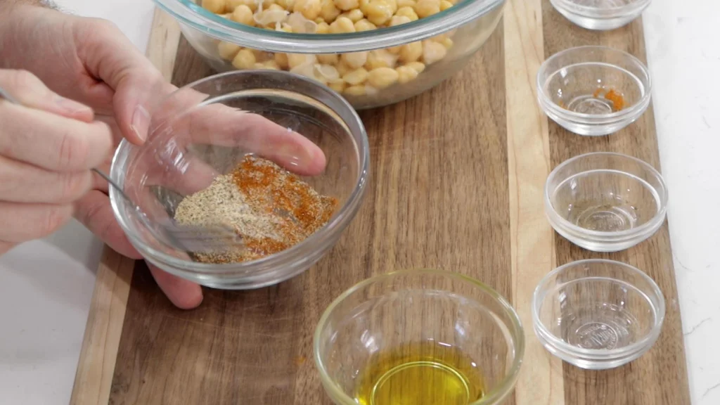 Hand mixing spices together in a small bowl.