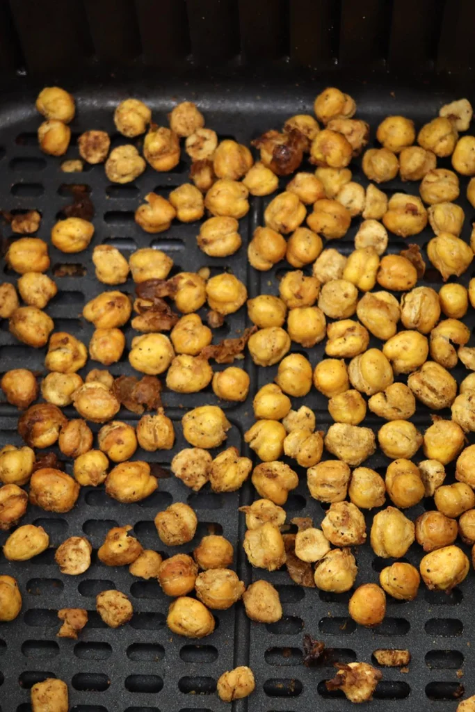 Roasted crispy chickpeas in air fryer basket.