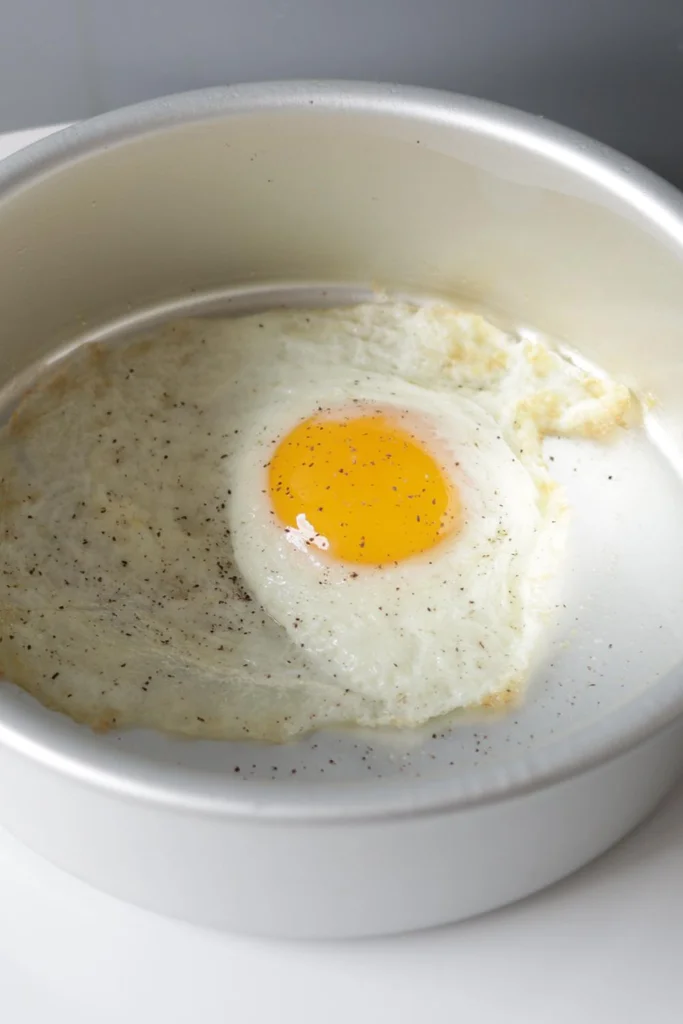 https://www.inthekitchenwithmatt.com/wp-content/uploads/2023/01/finished-fried-egg-still-in-cake-pan-LONG.webp