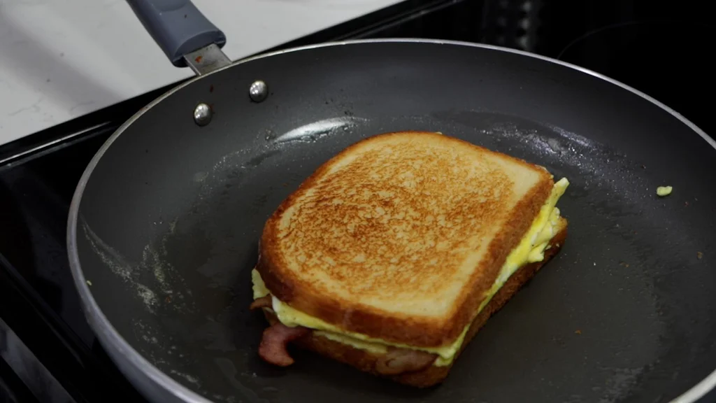Bacon egg and cheese sandwich in a skillet.