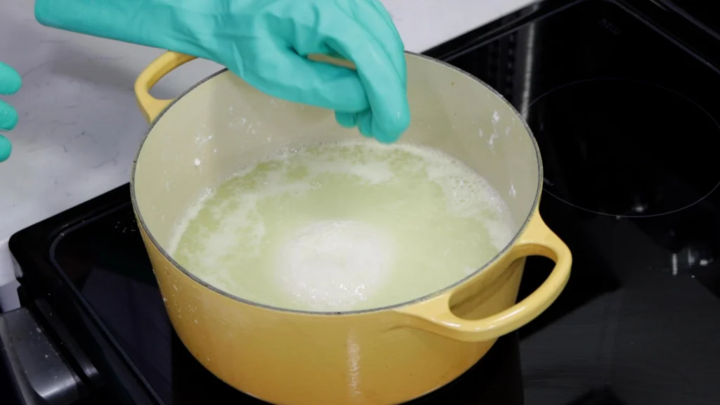 Ball of mozzarella cheese soaking in a pot of hot whey