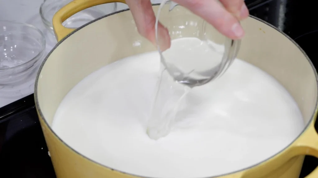 Pouring citric acid and water into milk