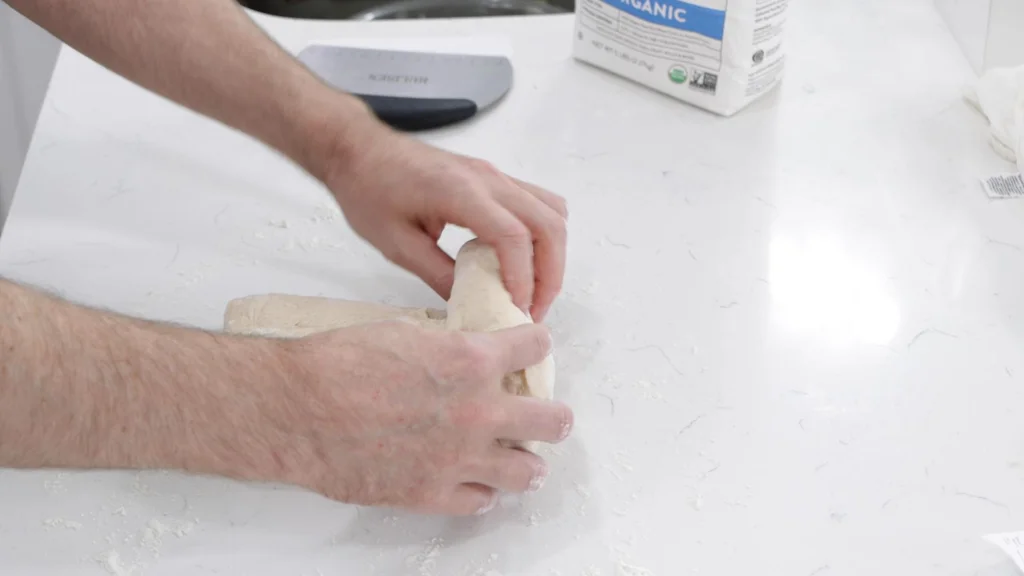 Fingers rolling up the dough.
