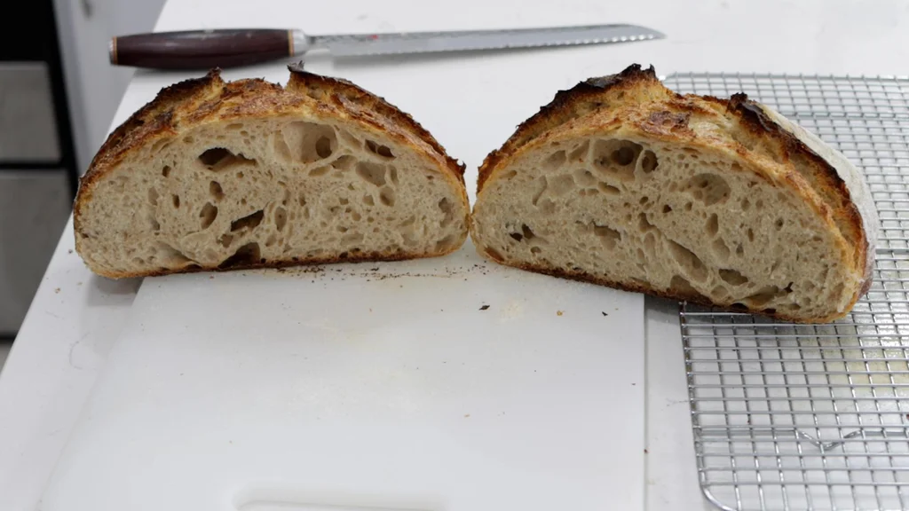 Sourdough bread cut in half on a cutting board.