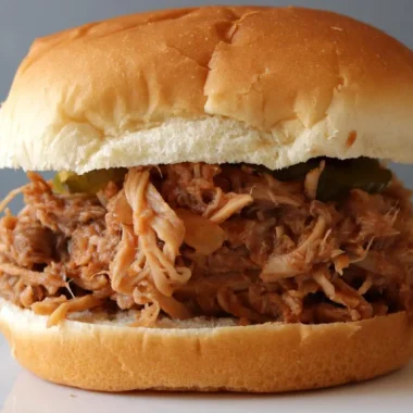Pulled pork sandwich on a white plate.