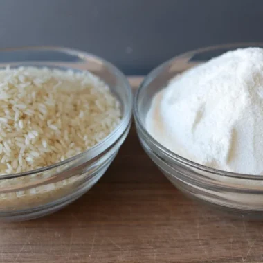 Bowl of homemade rice flour next to a bowl of rice.