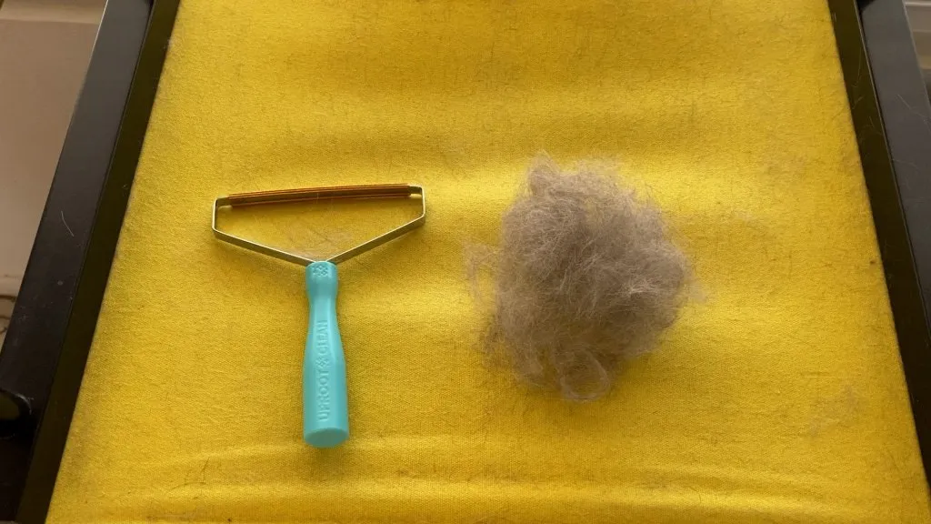 Uproot clean tool next to a big ball of cat fur.