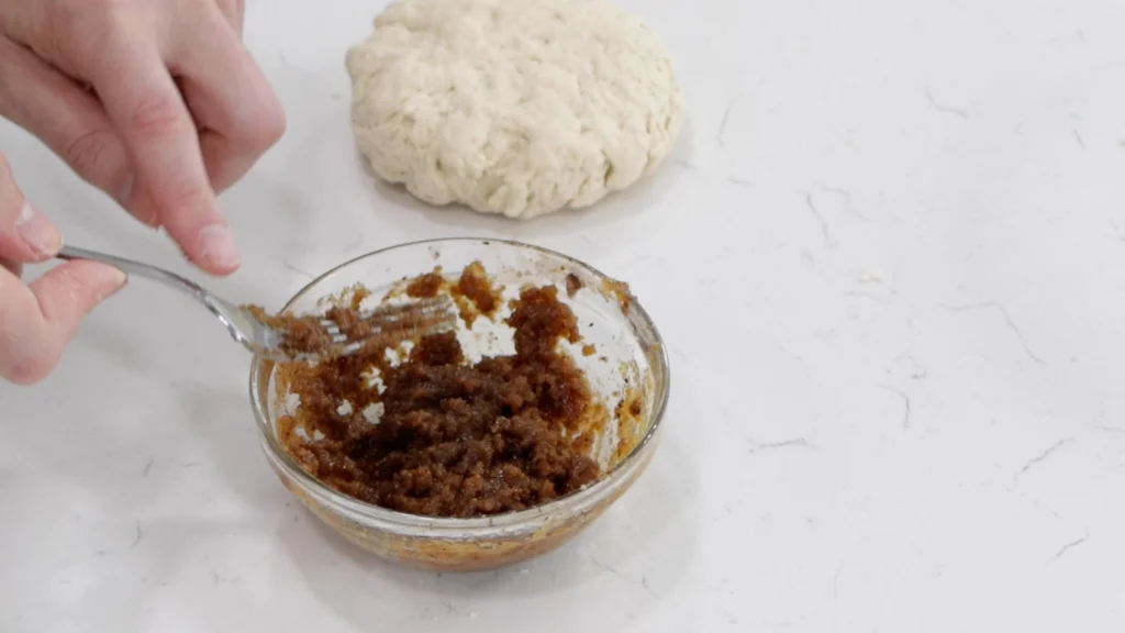 Fork mixing a sugar and butter paste.
