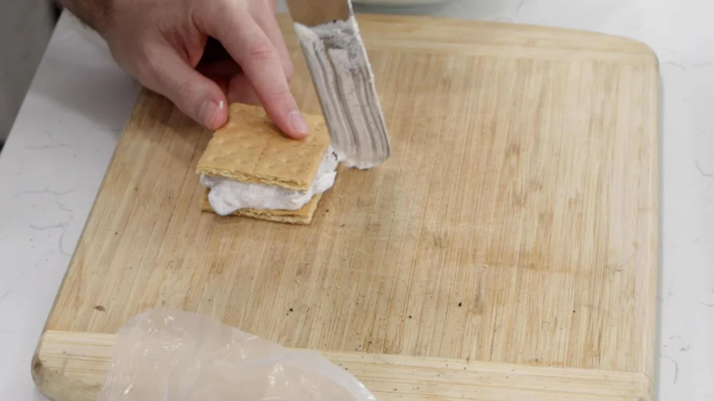 Spatula smoothing out the edges of an ice cream sandwich