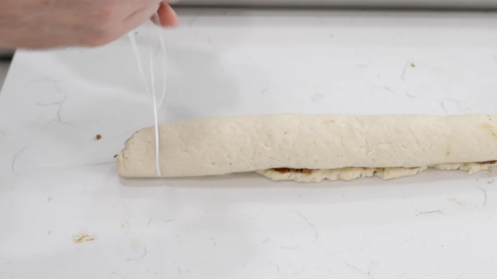 Using floss to cut the cinnamon rolls.