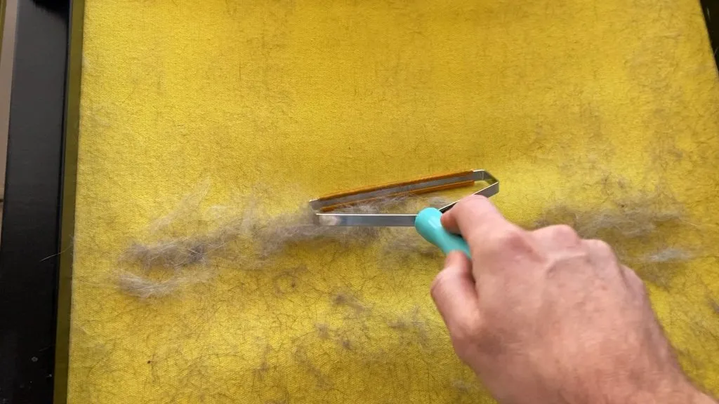 Hand using uproot clean tool on a canvas chair.