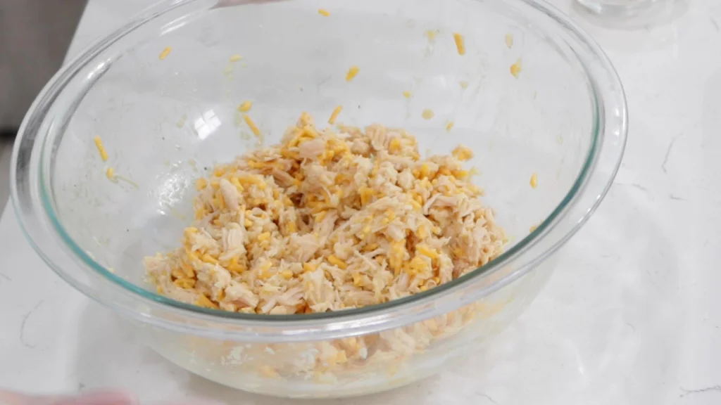 Bowl of canned chicken, cheese, egg, and a few spices all mixed together.