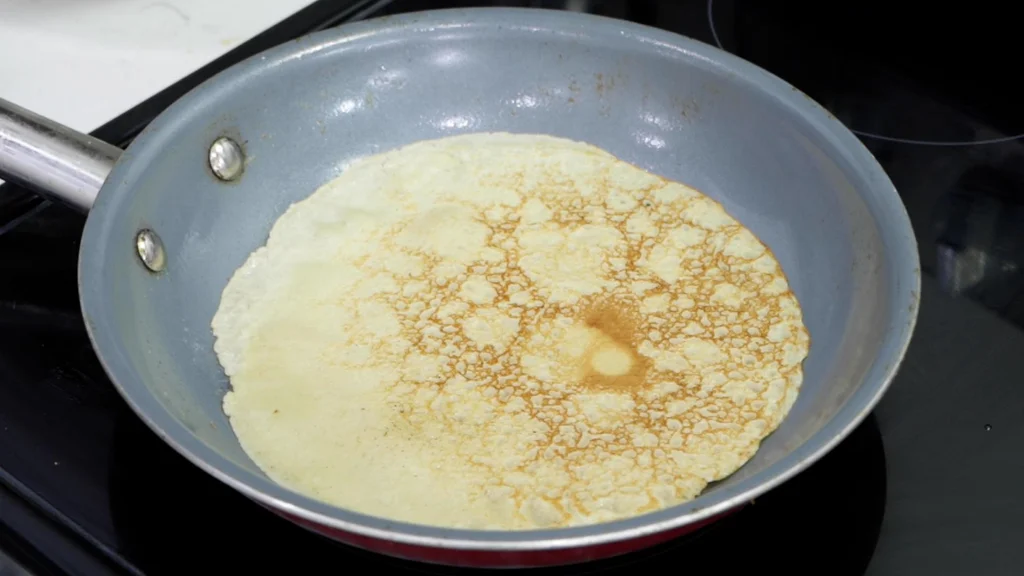 Cooked gluten-free crepe in pan.