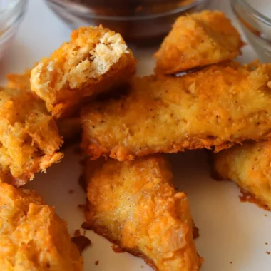 Homemade chicken fingers on a white plate.