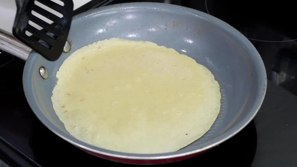 Crepe in pan ready to be flipped.