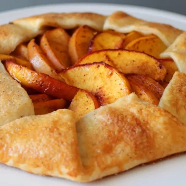 Homemade peach galette on a white plate.