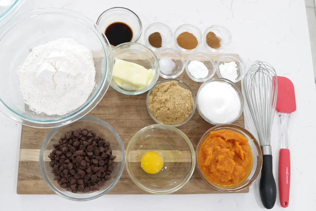 Several different baking ingredients in small glass bowls on a wooden cutting board. Several different baking ingredients in small glass bowls on a wooden cutting board.